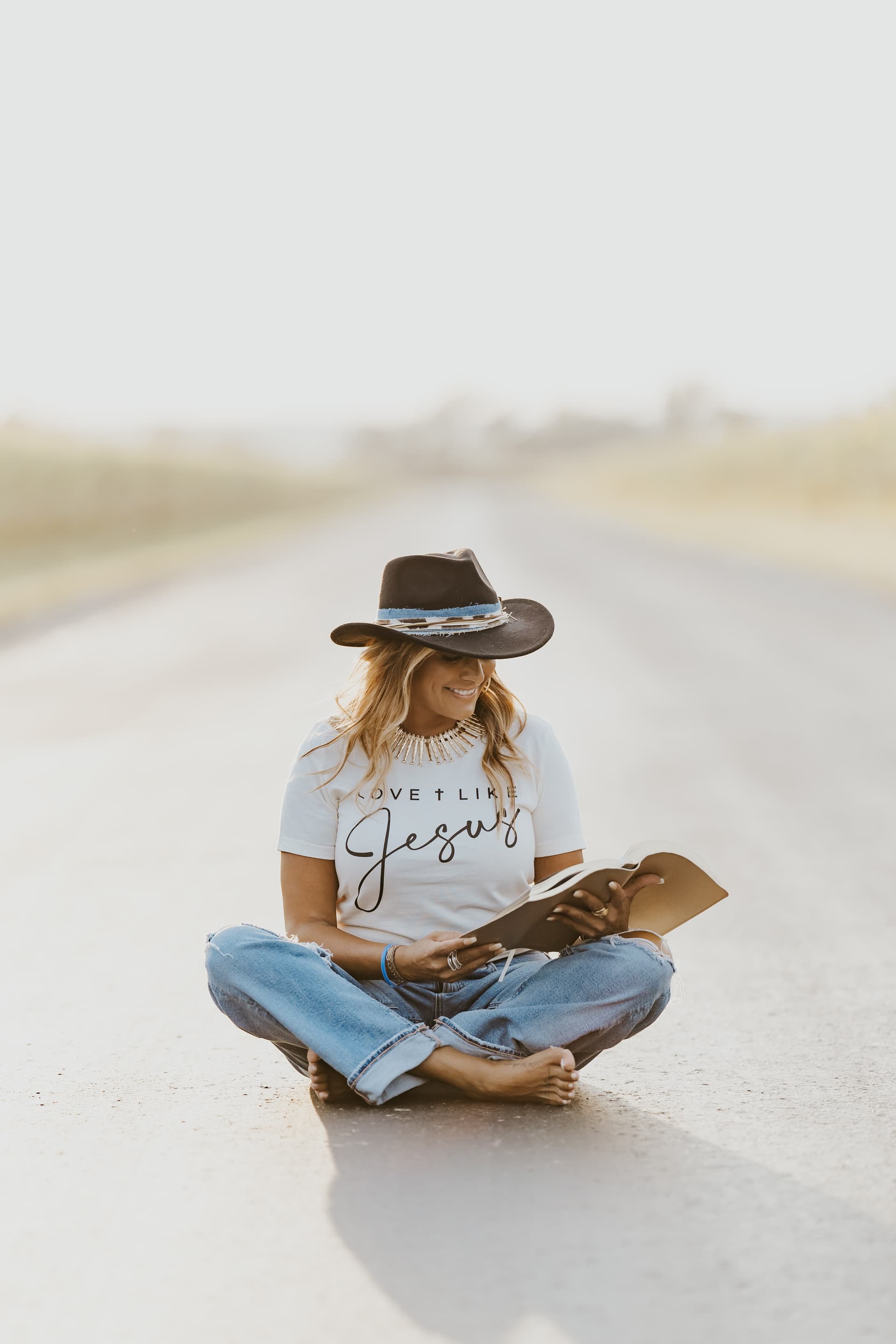 Naureen Stack-Frierdich reading on an open road